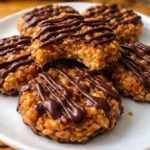 no bake samoa cookies with toasted coconut caramel and drizzled chocolate on a white plate