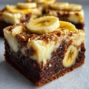 Delicious banana pudding brownies topped with whipped cream and banana slices.